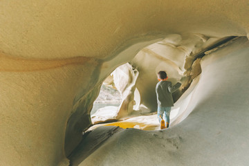 Little boy exploring sandstone caves
