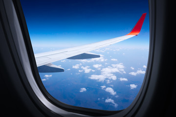 Wing airplane with blue sky and clouds from window,Beautiful blue sky view from commercial airplane window