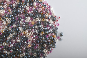 Multi-colored beads.Colorful beads on a wooden surface.It is used in finishing fashion clothes.Variety of shapes and color to make abead necklace or a string of beads toplease a woman of fashion.