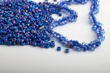 Multi-colored beads.Colorful beads on a wooden surface.It is used in finishing fashion clothes.Variety of shapes and color to make abead necklace or a string of beads toplease a woman of fashion.