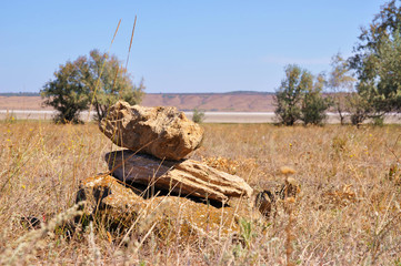 Sandstones stacked one on another like zen stone garden. Autumnal landscape of Kuyalnik liman salt lake in Odessa region of Ukraine. Bank of Kuyalnik estuary firth with lush dried grass. 