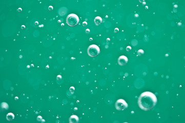 Beautiful turquoise background. Rising air bubbles in clear water. Oxygen. Macro