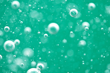 Beautiful turquoise background. Rising air bubbles in clear water. Oxygen. Macro