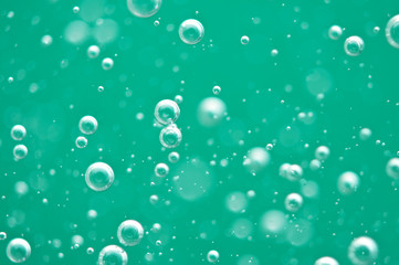 Beautiful turquoise background. Rising air bubbles in clear water. Oxygen. Macro