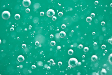 Beautiful turquoise background. Rising air bubbles in clear water. Oxygen. Macro
