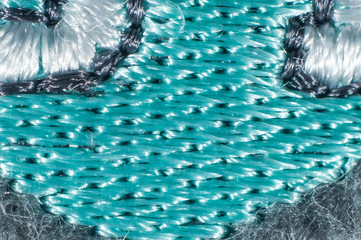 fabric with an insert of thin bright turquoise threads close-up macro photography