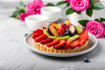 Tart with strawberries, kiwi, plums and cream