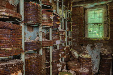 Destroyed from time to time storage room with stored old rusty round boxes with old film