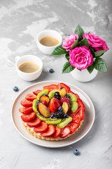 Tart with strawberries, kiwi, plums and cream