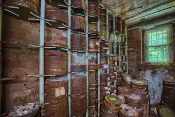 Destroyed from time to time storage room with stored old rusty round boxes with old film