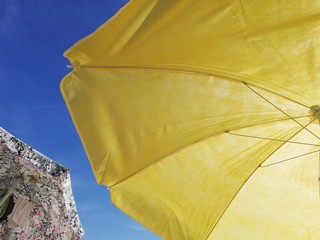 yellow umbrella on background of blue sky