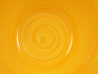  bottom of a yellow ceramic plate with a spiral pattern