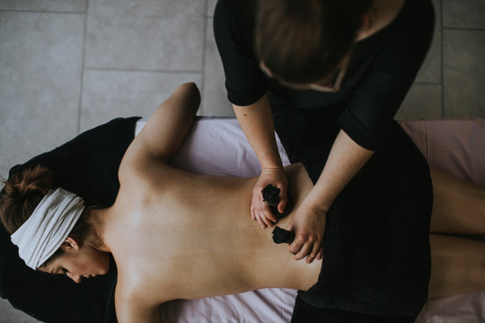 Young woman with sachets on her back during stamp massage