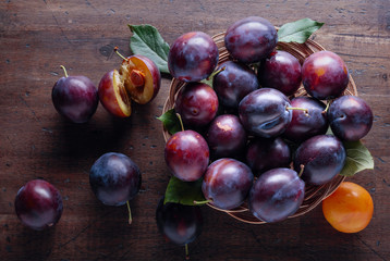 Ripe juicy plums on a wooden background.