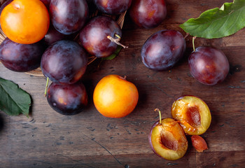 Ripe juicy plums on a old wooden table.