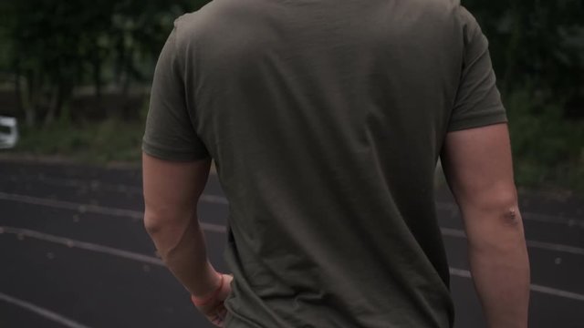 Fighter or athlete walks on an empty sports stadium. View from the back