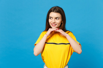 Portrait of smiling attractive young woman in vivid casual clothes looking aside, put hand prop up on chin isolated on bright blue background in studio. People lifestyle concept. Mock up copy space.