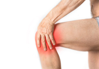Man is holding his aching knee with a hand