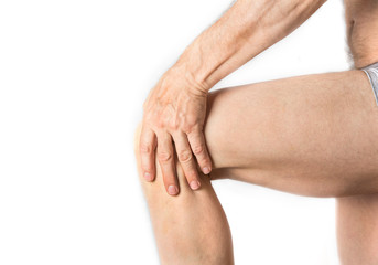 Man is holding his aching knee with a hand