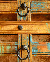 Details of a wooden chest made of recycled old ship planks with rivets and metal rings.