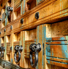 Details of a wooden chest made of recycled old ship planks with rivets and metal rings.