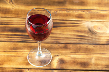 Glass of red wine on rusty wooden table