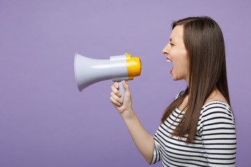 Young woman girl in casual striped clothes posing isolated on violet background studio portrait. People lifestyle concept. Mock up copy space. Scream in megaphone, announces discounts sale hurry up.