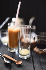 Ice coffee with condensed milk in tall glasses on black background