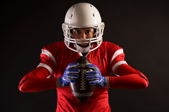 Image of american female football player in helmet with rugby ball in hands
