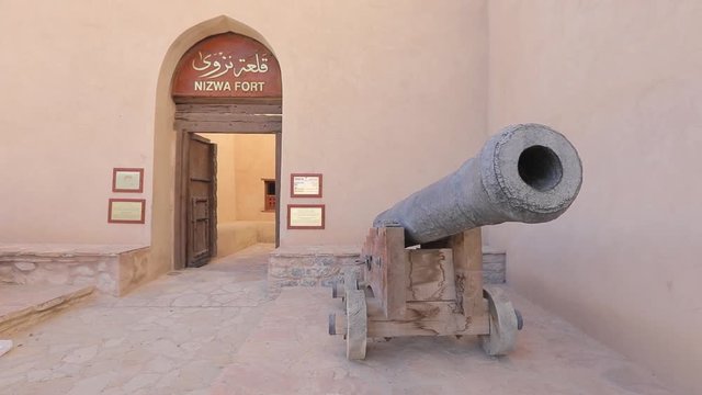 Nizwa Fort, Oman - February 2019. Traditional Omani fortress, general plan and details, guns and a flag on the main tower.