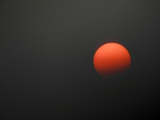 A reddish orange hazy summer sun