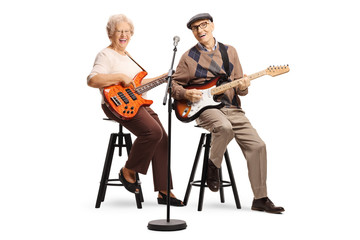 Fototapeta premium Senior man and woman sitting and playing electric guitars