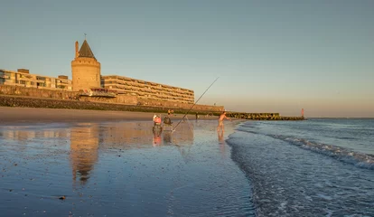 Deurstickers Fishing on the beach of Vlissingen at sunset © Erik_AJV