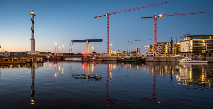 Old lighthouse of Ostend known as &lsquo;Lange Nelle&rsquo; at night, reflected in a commercial dock, Thursday 2 August 2018, Oostende, Belgium