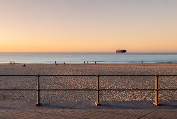 Container vessel on its way to the port of Zeebrugge at sunset.