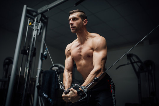 Young man doing chest exercise with cross machine-Edit