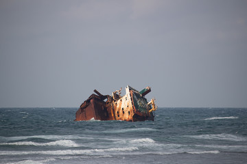 Fototapeta na wymiar Sunken ship at sea in the daytime