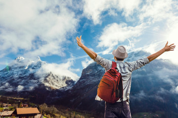 Man with backpack trekking in mountains. Cold weather, snow on hills. Winter hiking.