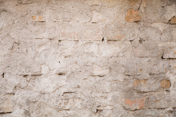 White brick wall for a background. Texture of  old, grungy brick wall with plaster. Abstract background gray. Texture with scratches and cracks.