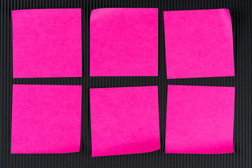 six pink notes lying on black corrugated cardboard. Concept reminder for girl or lesbian, schedule. Mock up, copy space, layout.