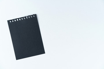 black sheet of notebook lie on a white background. The texture of the cardboard. Black list. Mock up, layout, copy space.