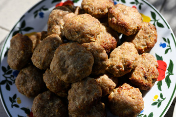 Several meatballs on a plate.