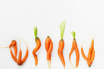 Ugly carrots on a white background. Ugly food concept, flat lay, copy space.