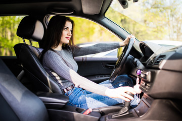Fototapeta na wymiar Young woman change speed holding hand on gearbox in the car