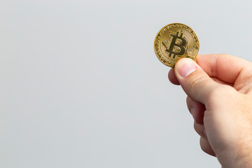 Plakat man hand holding a physical bitcoin