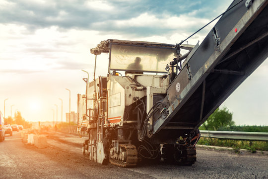 Asphalt Milling And Grinding Machine At Road Repair And Construction Site. Highway Renewal With Heavy Machinery