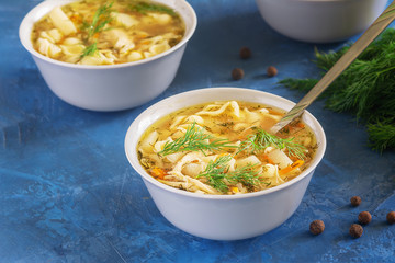 Chicken Noodle Soup Homemade Vegetable Dinner. Healthy Meal Portion in White Bowl. Poultry Broth with Organic Pasta Closeup. First Course with Dill on Top. Hot Nutritious Home Cooked Lunch
