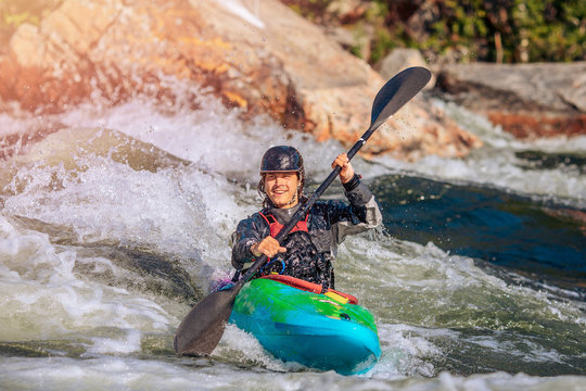 Guy in kayak sails mountain river. Whitewater kayaking, extreme sport rafting