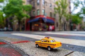 Vintage old Taxi toy in New York City most popular places. Classic Yellow Cab in Manhattan and Brooklyn. The symbol of New York. Driving a taxi through Brooklyn. 