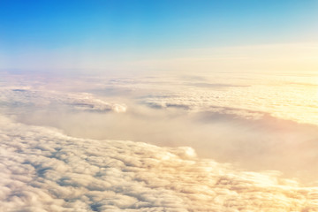 Fototapeta na wymiar Beautiful scenic dramatic morning sunrise cloudscape aerial view from plane window. Gradient colored fluffy clouds during aircraft flight travel at sunset. Natural sky background